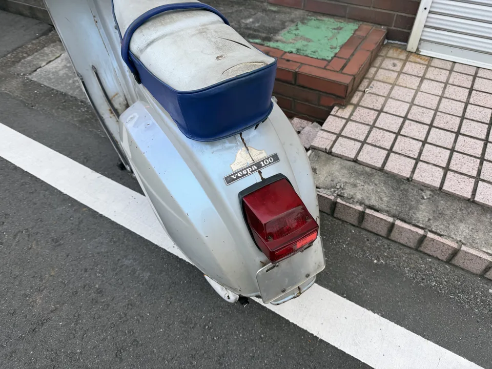 ベスパ100を後ろから見たところ。シートに裂け、リアフェンダーにひび割れとサビがある